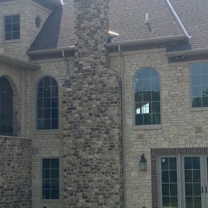 Erie Shore buff split veneer with jumpers and Fon-du-lac Brookwood Chimney and accent wall on residential home.